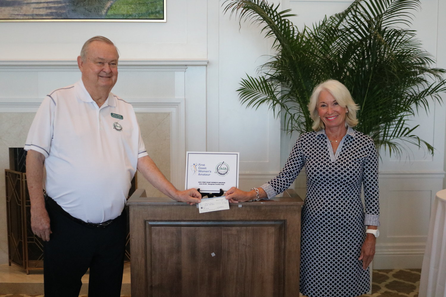 Melissa Gotfredson with the First Coast Women’s Amateur Championship presented a $1,000 check donation to Wayne St. Clair and the JAGA scholarship committee.